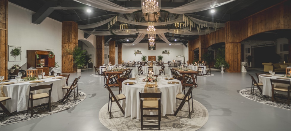 An indoor room with tables set for a wedding