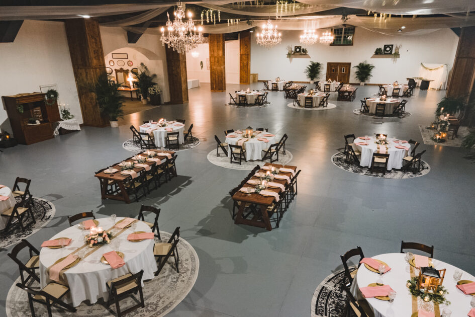 A view of a large room with tables set for a wedding